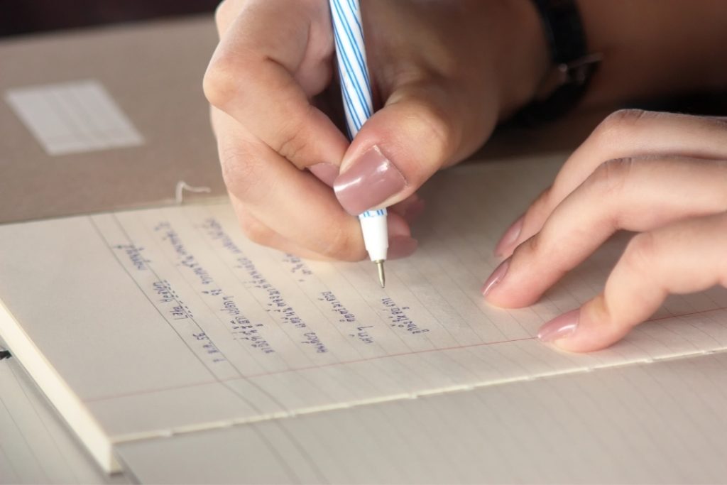 Mujer escribiendo una carta con un bolígrafo