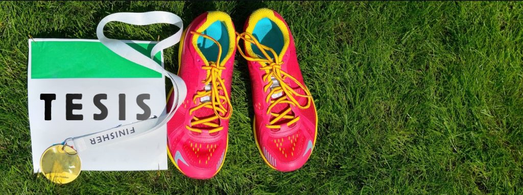 Zapatillas de maratón en colores vistosos junto a dorsal y medalla